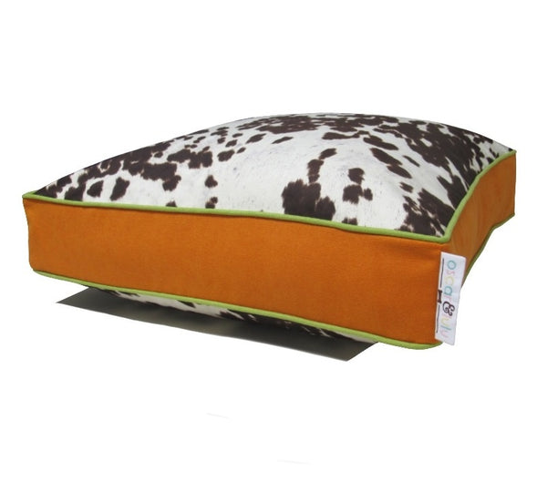 Brown & cream faux cow hide dog bed, orange sides & bottom with light green piping